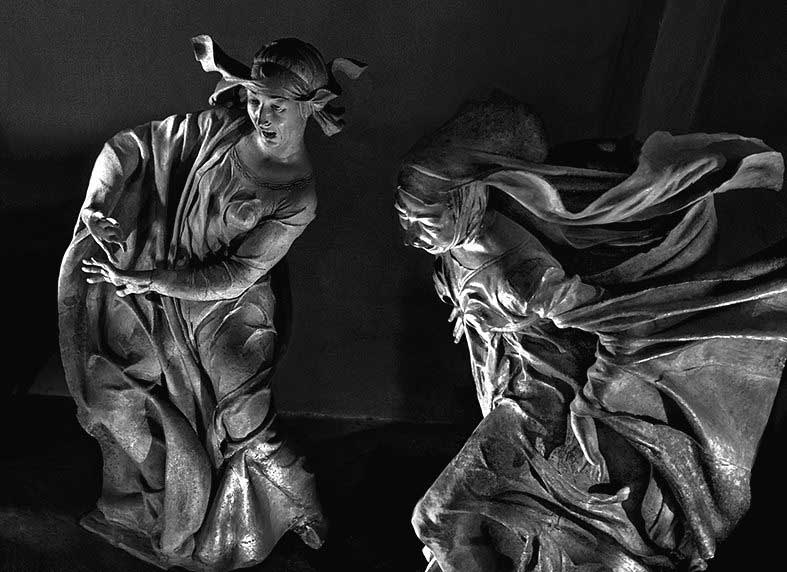 fotografia di due statue di donne in movimento